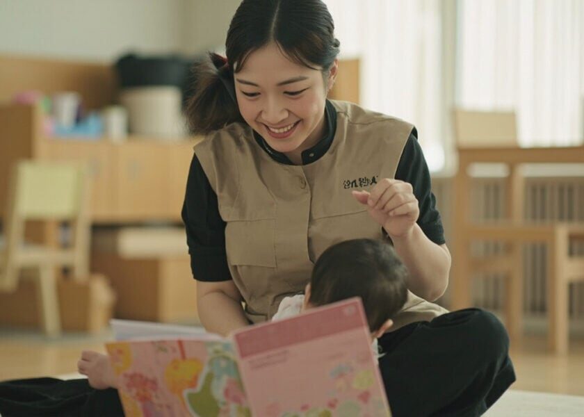 Childminder and infant sharing a cloth book during attentive floor time