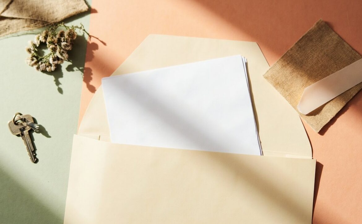 Warm overhead still life of blank papers in a folder, household keys and linen in soft natural light.