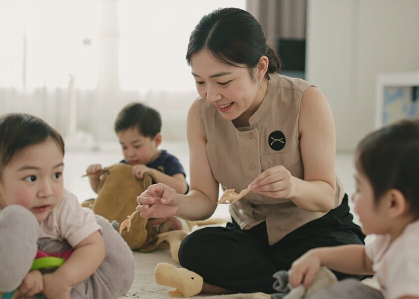 AI illustration of a childminder supervising three awake infants on a clean mat in a Singapore home