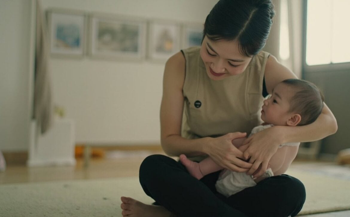 AI illustration of a childminder supporting an awake infant in a generic Singapore home