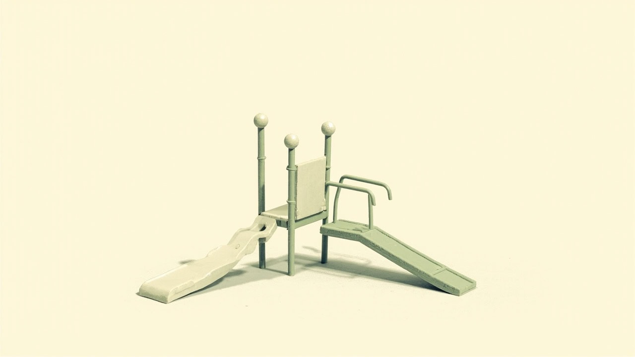 Stylised empty modular playground with a small slide, raised platform, rails and sloping ramp on a plain ivory background.